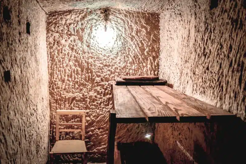 air raid shelter with wooden bed and chair
