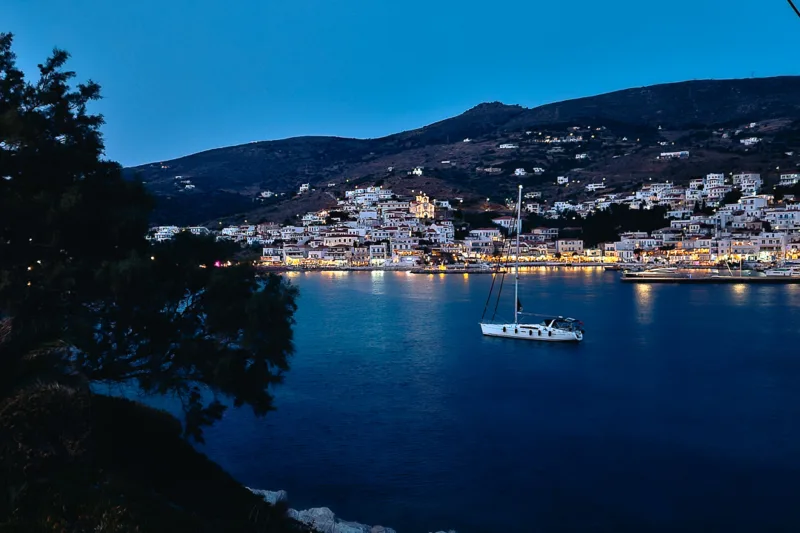 batsi harbour night view with boat in foreground and village houses in background