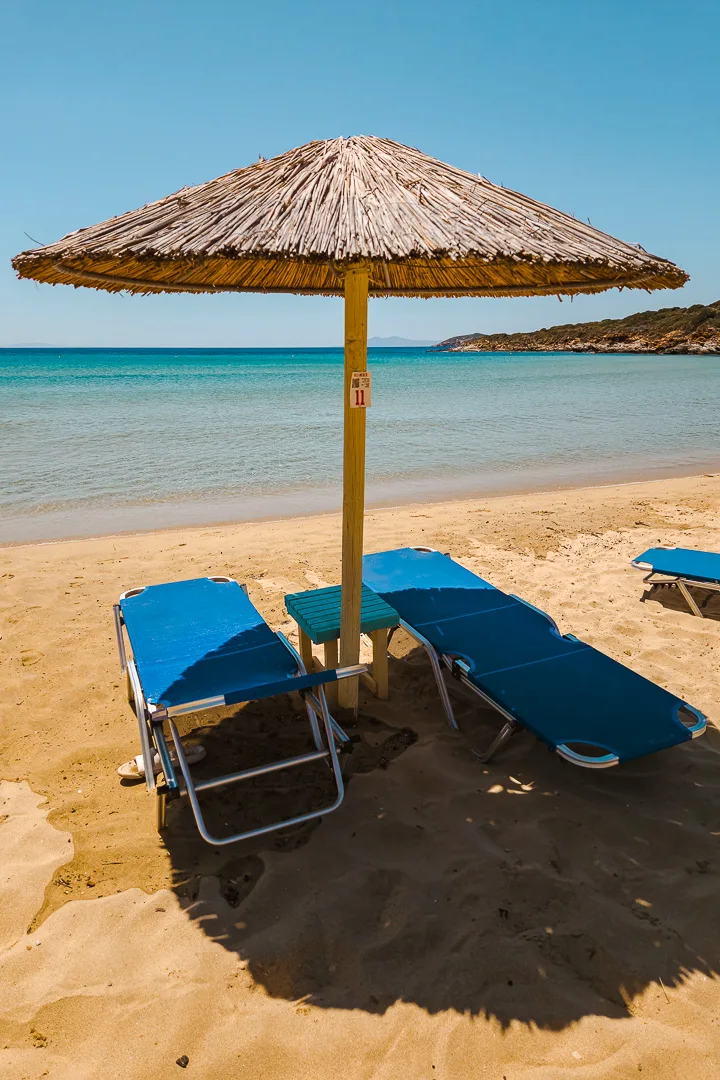 sunbeds and umbrella on golden beach, andros