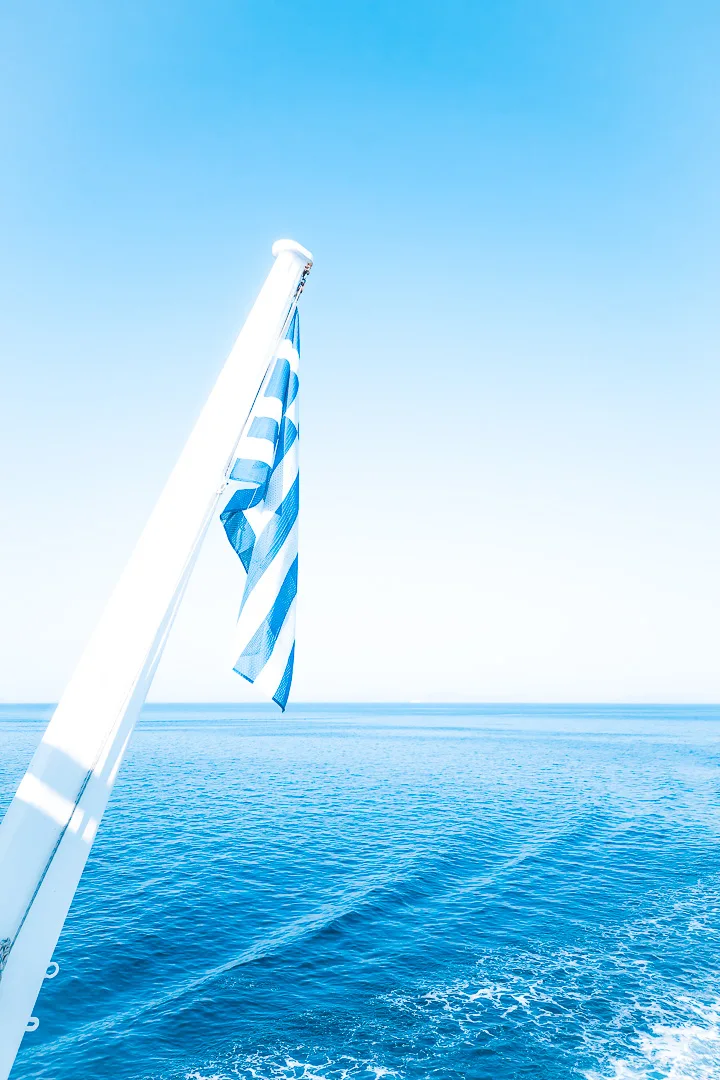 greek flag flying from back of ferry