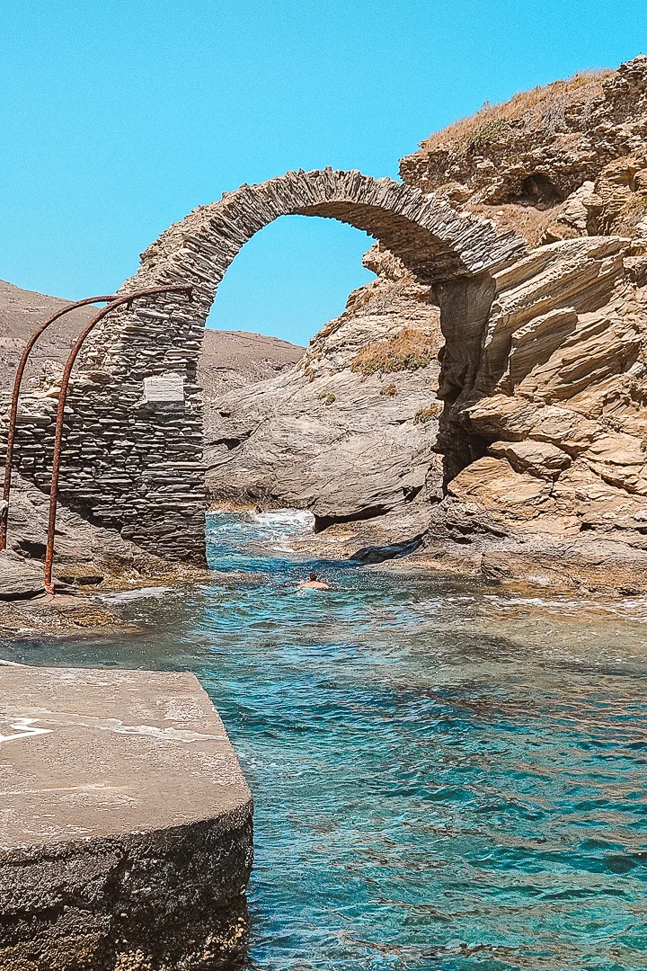 man swimming under bridge at the venetian castle, chora