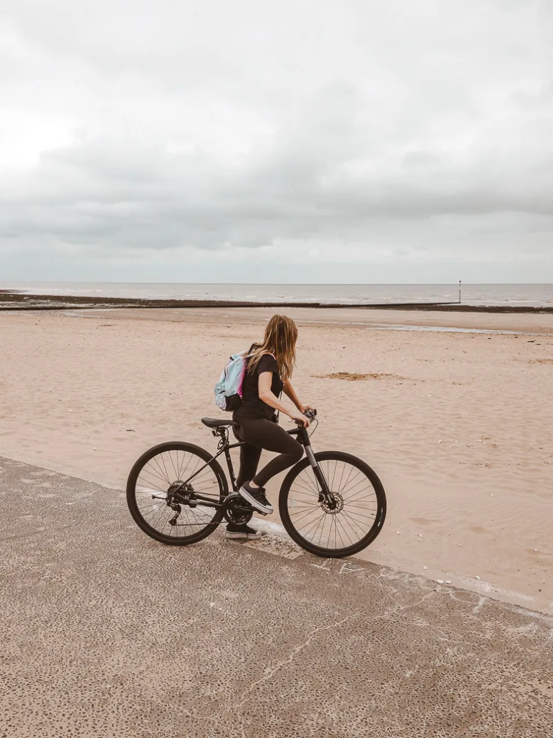 woman on a bike in front of margate beach