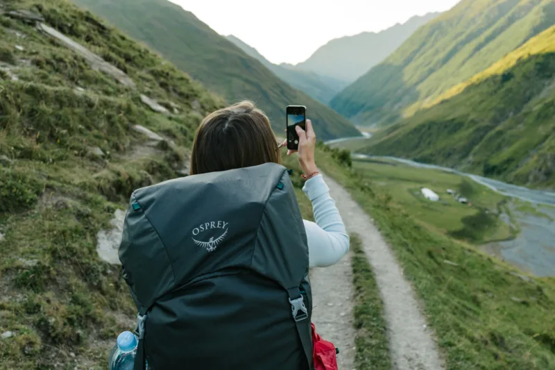 person looking at phone in mountains